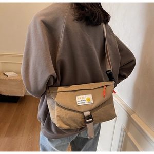 Vista posteriore dettagliata della borsa kaki con fibbia e tirante della zip arancione