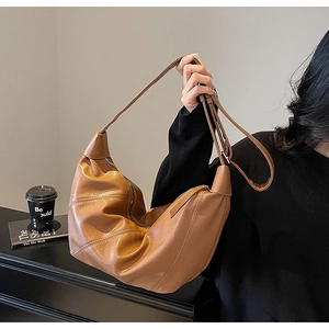 Dettaglio borsa hobo in ecopelle marrone con tracolla regolabile e finitura materica
