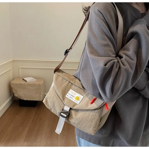 Dettaglio della borsa a tracolla in nylon kaki con tracolla regolabile e spilla smiley