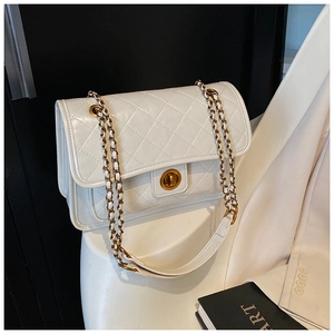 Detail of white quilted handbag featuring gold circular turn-lock and elegant chain strap