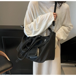 Dettaglio della borsa utility in nylon nero con ganci metallici e mini pochette rimovibile