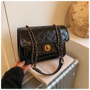 Close-up of black quilted leather bag featuring a vintage gold metal twist lock buckle