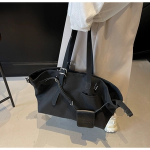 Dettaglio della borsa tote grande in nylon nero con ciondolo ASML e fibbie metalliche