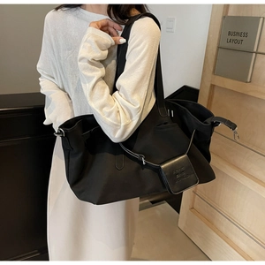 Dettaglio tote bag nera in nylon con ganci argento e astuccio ACNE THE WORLD