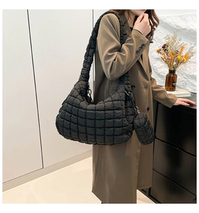Close-up of black quilted puffer cloud bag with matching mini coin purse detail