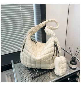 Detail of quilted puffy tote bag in off-white with matching small pouch charm