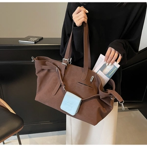 Dettaglio della borsa tote marrone opaco con fibbia regolabile e pochette accessoria azzurra
