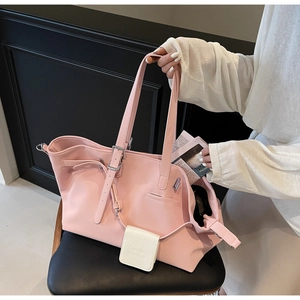 Dettaglio borsa tote vintage rosa con fibbia argento e mini pochette bianca appesa