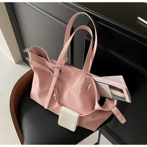Dettaglio della borsa tote rosa con pochette bianca su una sedia elegante