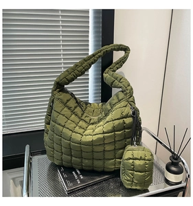 Detail of army green quilted cloud bag with matching mini pouch on a metal rack