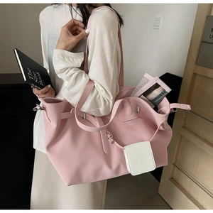Dettaglio della grande borsa tote rosa con portafoglio bianco e tracolla regolabile