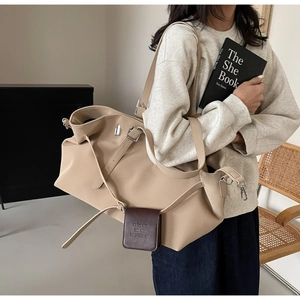 Dettaglio della borsa tote beige con mini pochette marrone rimovibile e logo in rilievo
