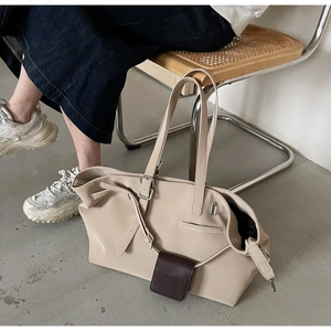 Dettaglio della borsa tote beige con una piccola pochette in rilievo marrone scuro