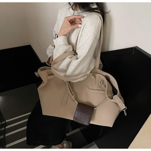 Dettaglio della borsa tote kaki con logo del marchio in rilievo sulla targhetta in pelle