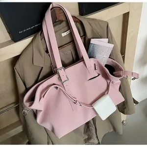 Dettaglio della borsa tote in pelle rosa con una mini pochette bianca su un supporto