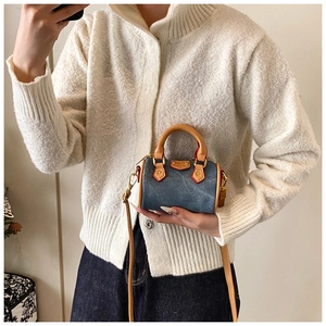 Vue détaillée du mini sac Boston en denim avec anses en cuir marron et détails dorés