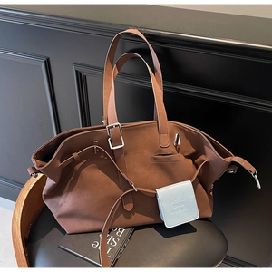 Dettaglio della borsa tote marrone scamosciata con fibbia e mini pochette azzurra