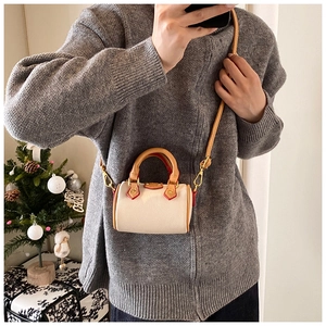 Mini sac Boston crème avec lanières marron porté avec un pull en tricot d'hiver