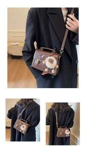 Detail view of brown vintage satchel with gold buckle and cute puppy pattern