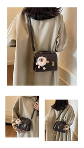 Detail of dark brown leather crossbody bag with cute dog applique and furry charm accessory