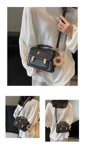 Detail of black PU leather square bag with dachshund embroidery and lion plush charm