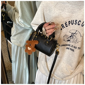 Détail du mini sac Boston en cuir noir avec clous métalliques et breloque ours en peluche