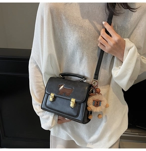 Detail of black vintage crossbody bag with dachshund patch and plush lamb charm