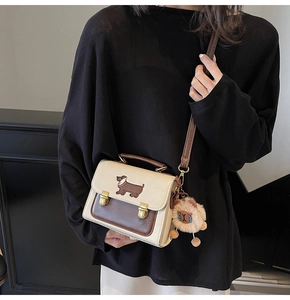 Detail of a contrast color square crossbody bag featuring a cute dachshund embroidery patch