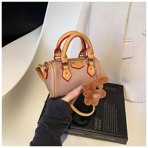 Mini sac Boston en cuir rose avec poignées jaunes et un charmant ours en peluche