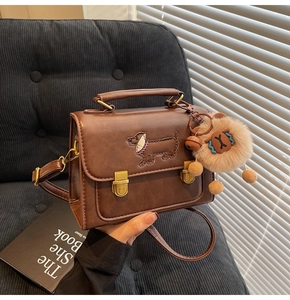 Detailed embroidery of a dachshund dog on a brown vintage-style PU leather crossbody bag