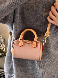 Mini sac polochon rose avec bandoulière en cuir marron et détails dorés brillants