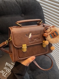 Brown leather crossbody bag with dachshund embroidery and teddy bear charm on handle