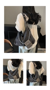 Detail of dark gray denim tote bag featuring chunky silver chain and mini pouch charm