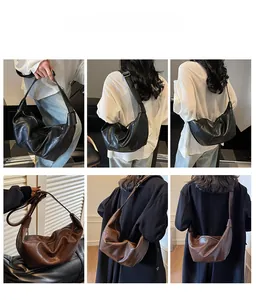 Detail showing the black and brown dumpling bag worn as a shoulder or crossbody bag