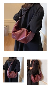 Detail of burgundy hobo bag with vintage pleated texture and adjustable strap