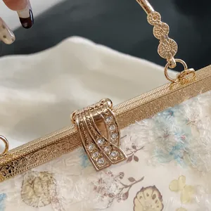 Makroaufnahme des Vintage-Goldrahmens mit Blumenmuster und Strass-Schnalle an der Tasche