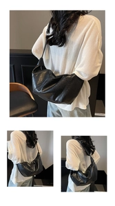 Detail of black glossy pleated leather hobo bag showing large capacity and soft texture