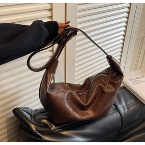 Detail of vintage dark brown crescent bag with smooth zipper and leather strap puller
