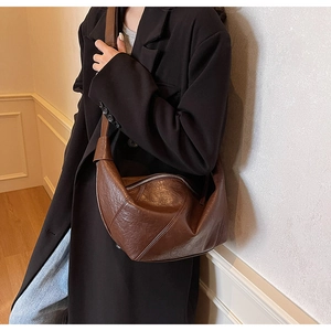 Detail of vintage brown crescent bag with pleated oil wax leather and wide strap
