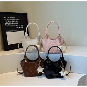 Détail de mini sacs seaux en quatre couleurs avec breloques mouton et anneaux en métal