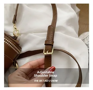 Detail view of the adjustable brown leather strap with polished golden buckle and hardware