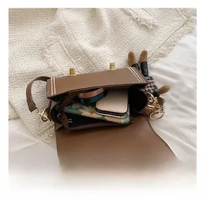 Detail view of large interior capacity of brown leather crossbody bag with golden hardware