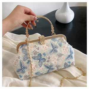 Detail einer bestickten Blumenhandtasche mit Gold-Schmetterlingen und Retro-Verschluss