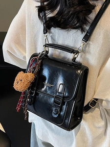 Fashionable black glossy mini backpack with metal handle and cute bear charm for women