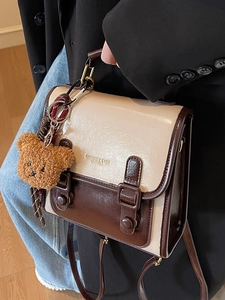 Vintage brown and beige messenger bag with plush bear charm and metallic buckles