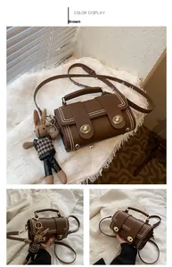 Brown vintage leather handbag with metal studs, adjustable strap and rabbit charm accessory