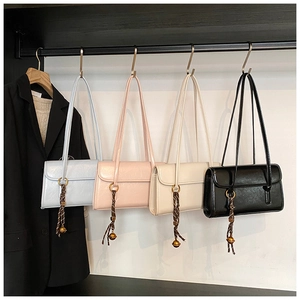 Detail view of stylish large underarm bags in four colors with decorative knot charms