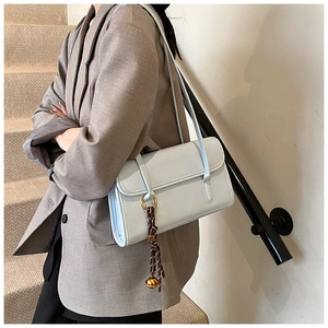 Close-up of light blue baguette shoulder bag with gold ring and silk scarf detail