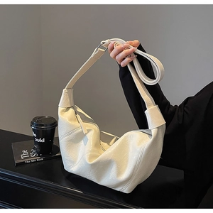 Detailed view of the soft beige hobo bag with subtle pleats and silver metallic zipper