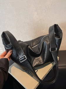Retro black dumpling crossbody bag in matte faux leather with wide adjustable strap